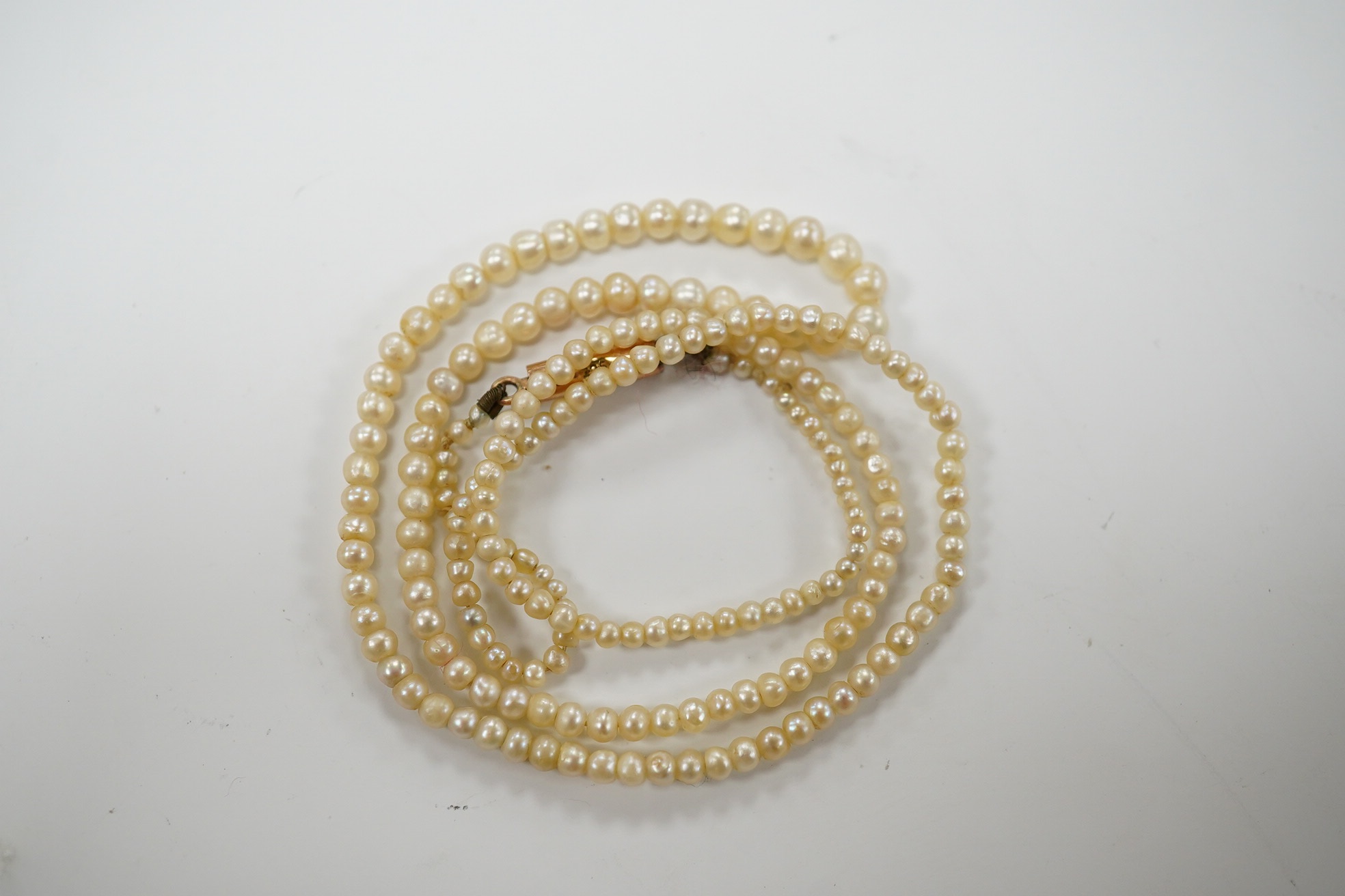 An early 20th century single strand graduated seed pearl necklace, with 9ct barrel clasp, 38cm. Condition - fair